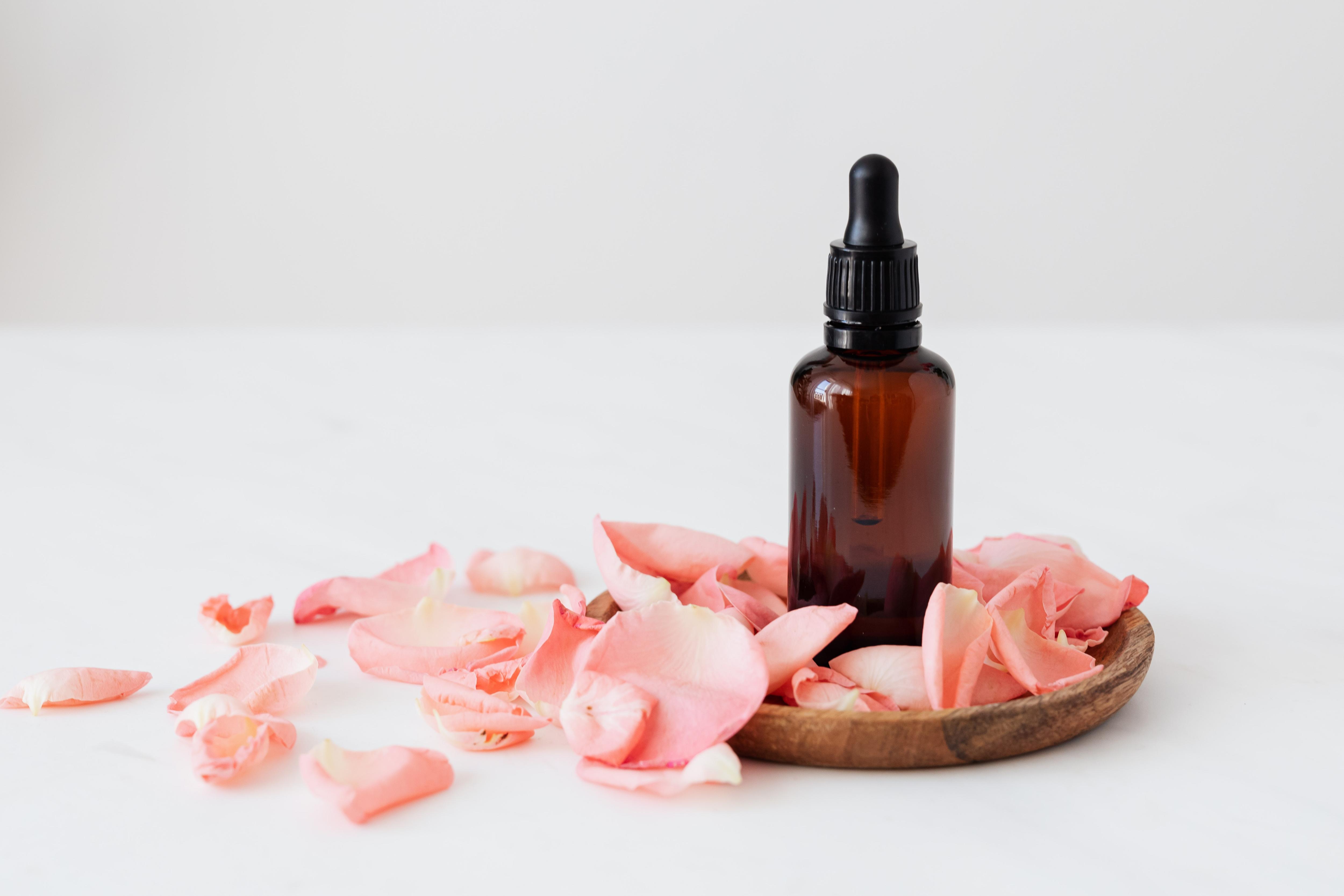Essential oil bottle among rose petals in a story about MLMs and why to avoid them.
