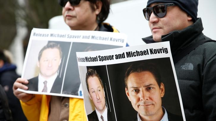 People hold signs calling for China to release Canadian detainees Michael Spavor and Michael Kovrig.