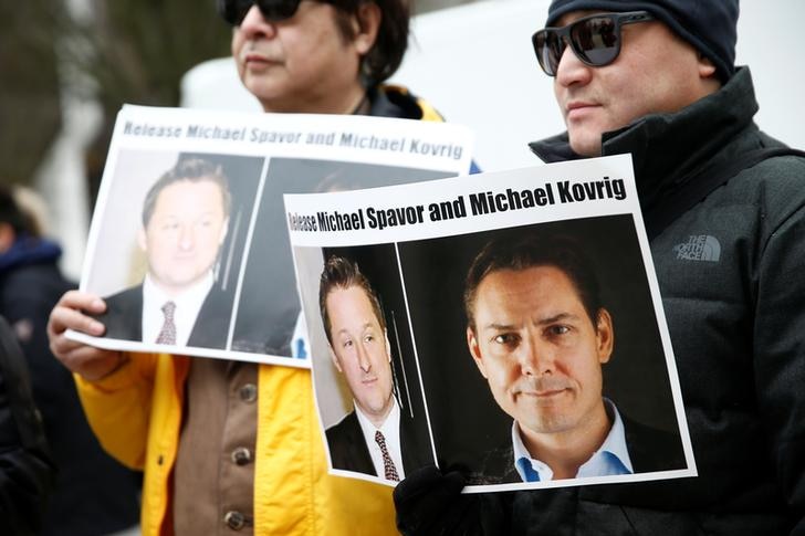 People hold signs calling for China to release Canadian detainees Michael Spavor and Michael Kovrig.