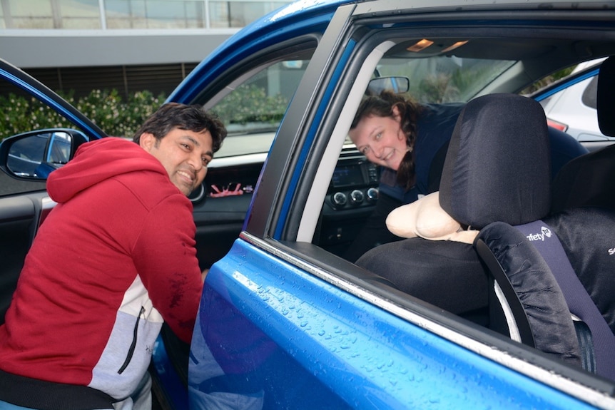 Ashish Sahi (father) and Bridget McIntyre (nurse) by the blue sedan that Mahima gave birth in.