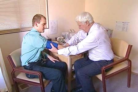 A doctor takes his patient's blood pressure.