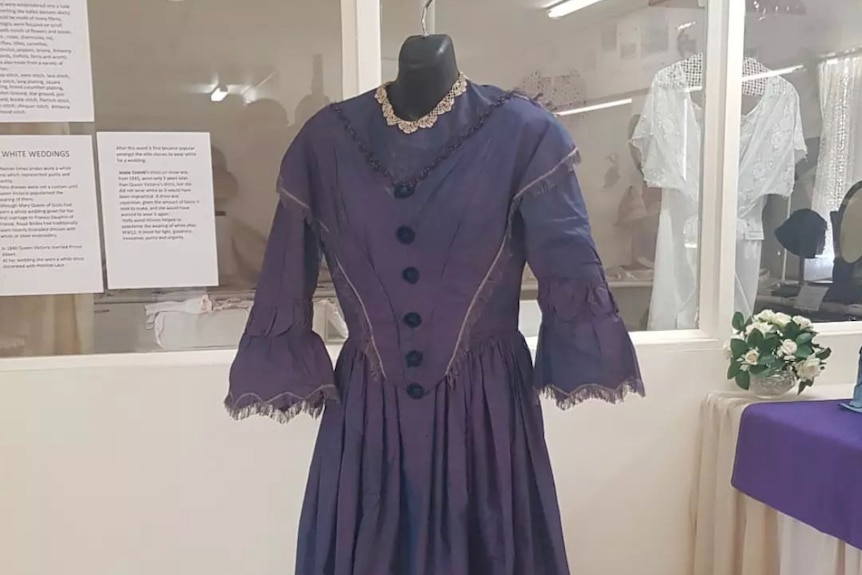 A vintage purple dress on a hanger.