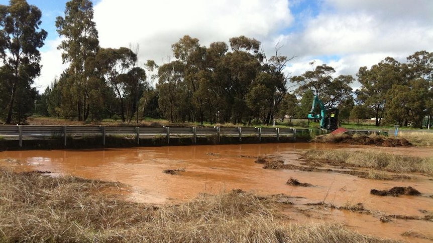 Coolamon Shire Council workers clearing debris from the Bygoo Creek bridge at Ardlethan on August 28, 2015.