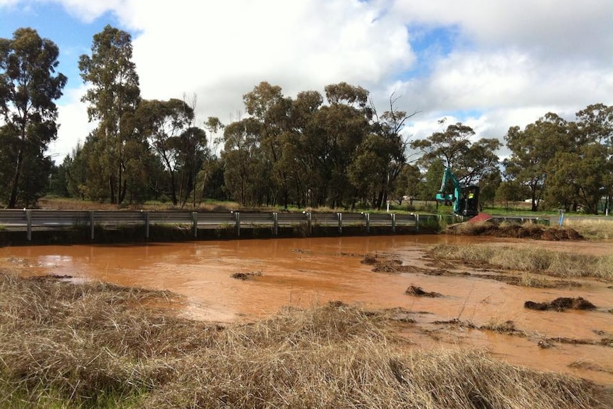 Coolamon Shire Council workers clearing debris from the Bygoo Creek bridge at Ardlethan on August 28, 2015.