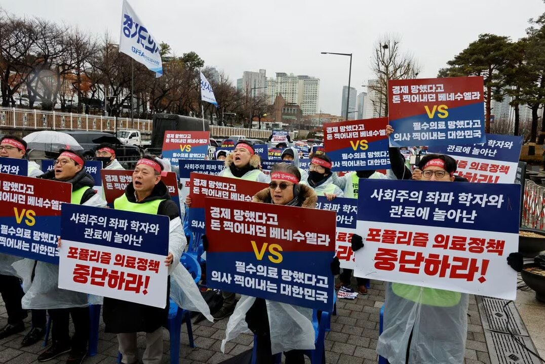 A group of people holding large, bright coloured signs during a protest