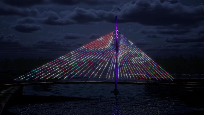 A triangular bridge lit up with artwork in purple, red and green at night.