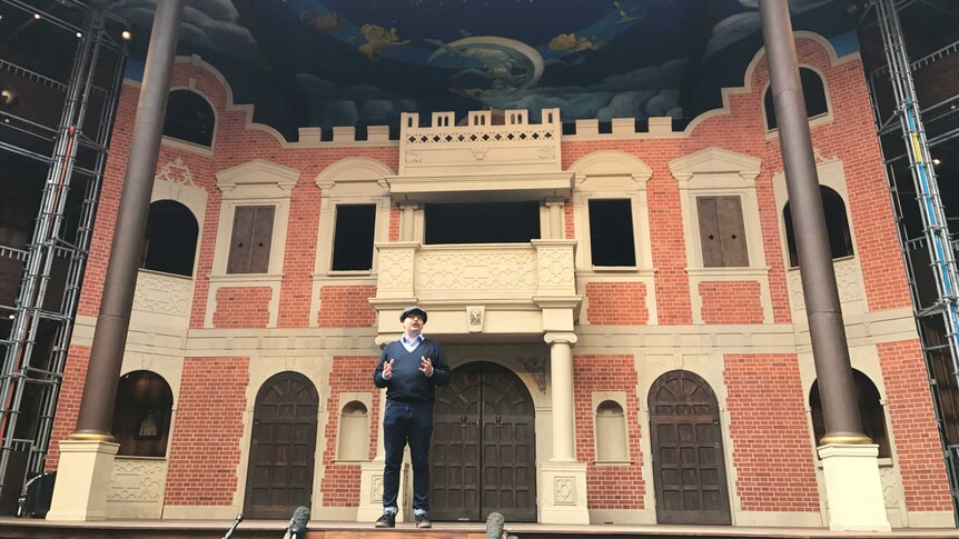 Pop-up Globe artistic director Miles Gregory stands on the stage of the replica theatre.