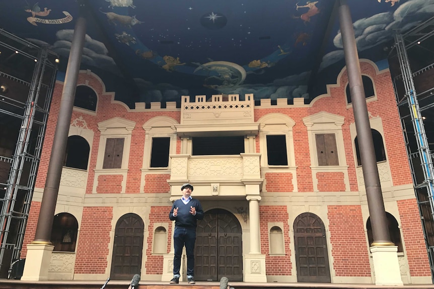 Pop-up Globe artistic director Miles Gregory stands on the stage of the replica theatre.