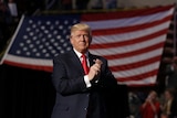 Donald Trump in front of an American flag. 