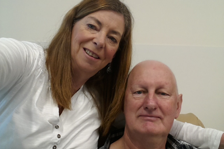 A selfie of a man and a woman smiling at the camera