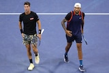 Thanasi Kokkinakis and Nick Kyrgios look up at the scoreboard during their doubles match at the US Open.