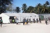 A man is taken away by security contractors in the detention centre on Manus Island
