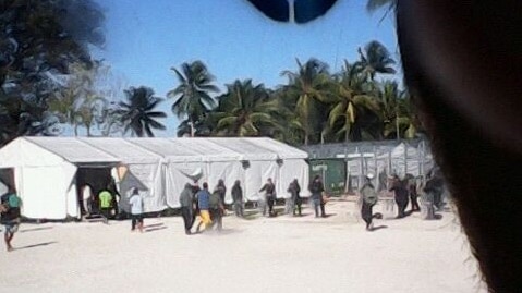 A man is taken away by security contractors in the detention centre on Manus Island