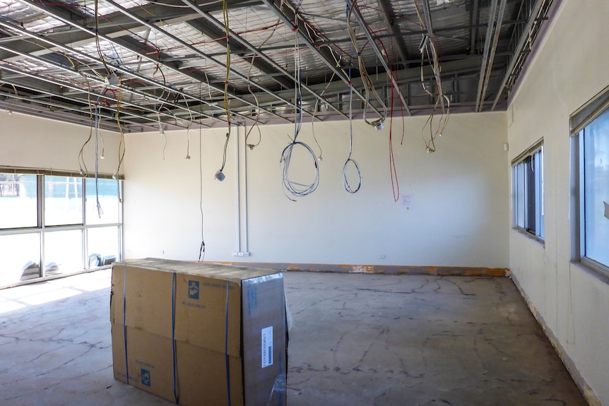 An empty room with cables hanging from the ceiling.