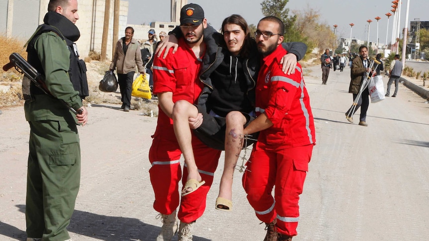 Volunteers from the Syrian Arab Red Crescent carry a sick man out of al-Mouadamiya.