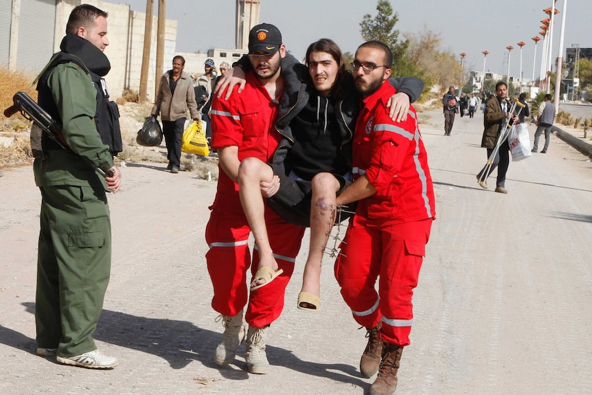 Volunteers from the Syrian Arab Red Crescent carry a sick man out of al-Mouadamiya.