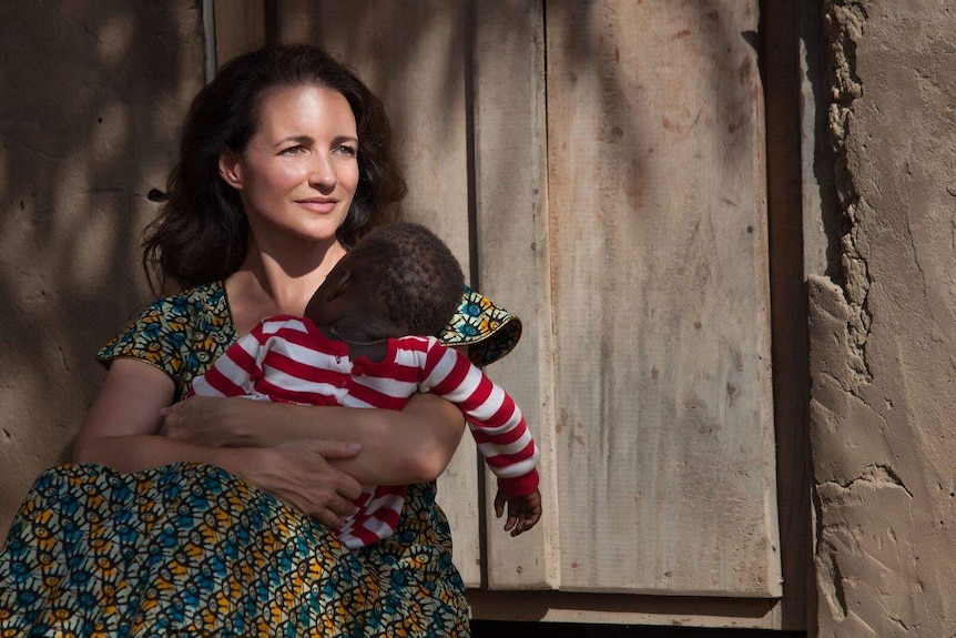 Actress and humanitarian Kristin Davis holding a baby in Africa.