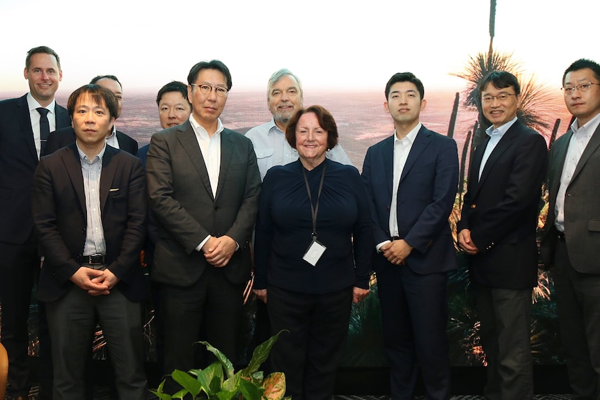 A group of men and one woman, all dressed in suits.