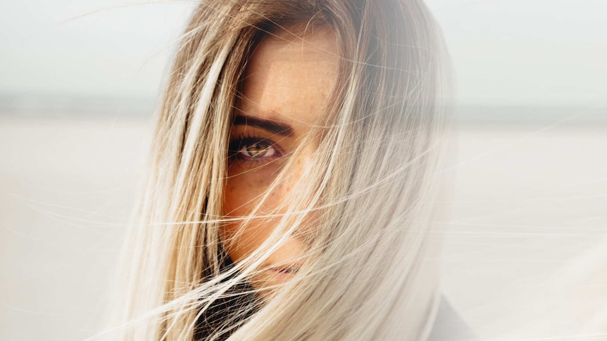 Close up of a woman's face half of it fading to nothing.