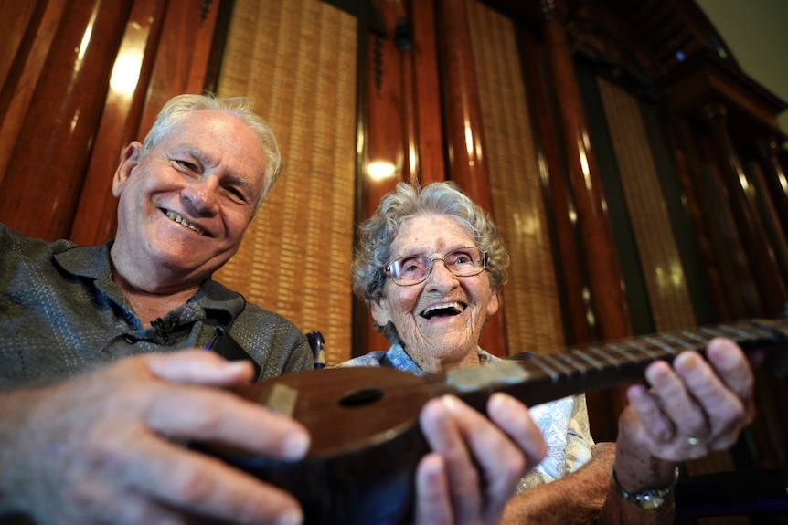 Graham and Grace Caddies holding a makeshift ukelele.