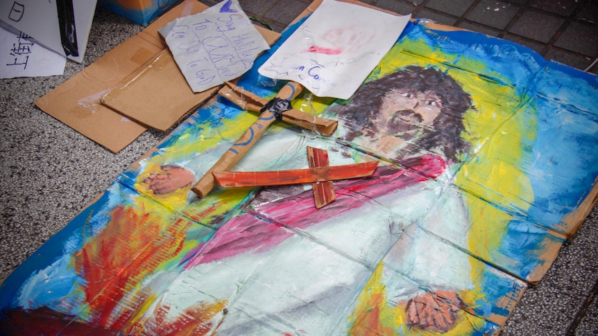 Cartoon drawings of Jesus and a cross on the ground