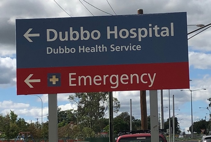 A sign reading Dubbo Hospital, a red emergency sign underneath with an arrow pointing to the right.