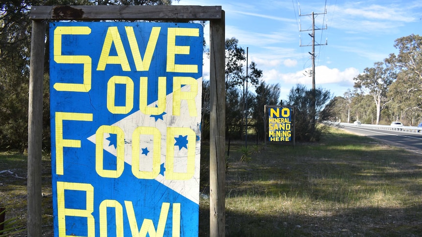 Two signs along a highway which carry anti-mining slogans.