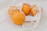 netted bag containing navel oranges