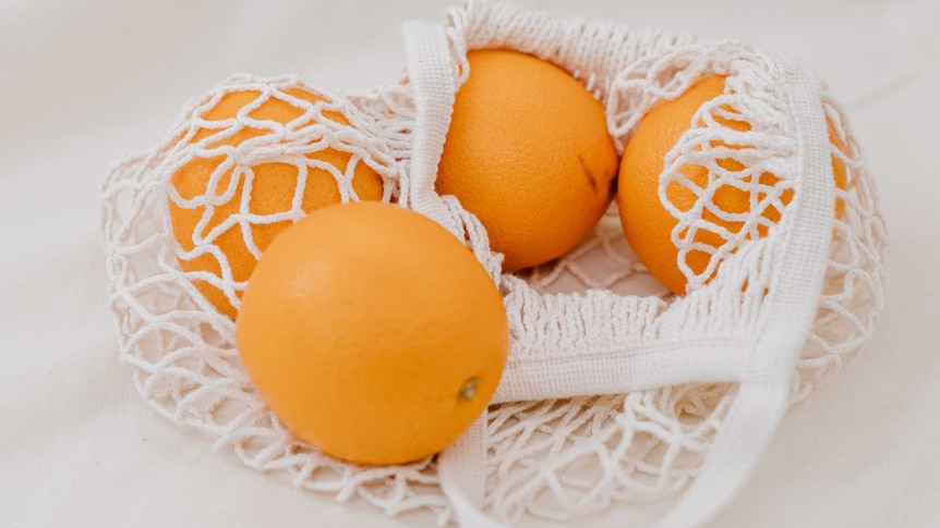 netted bag containing navel oranges