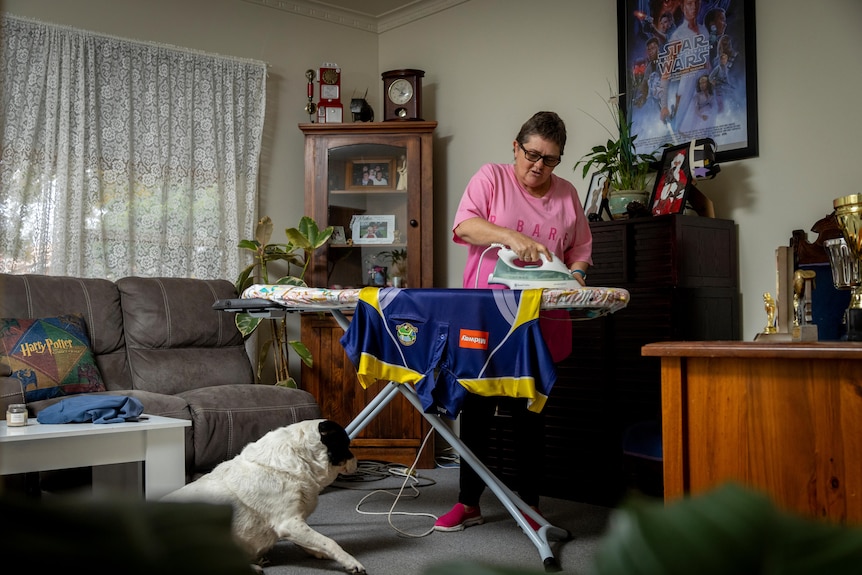 Darlene Badenoch ironing her Moonee Ponds Bowls Club shirt in her living room. 