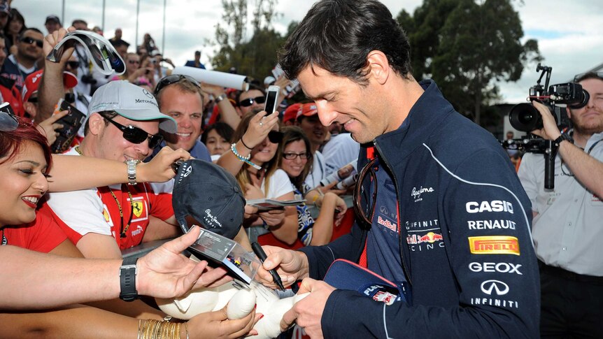 Mark Webber signs autographs for fans in Melbourne.