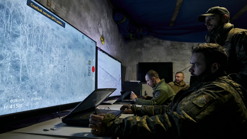 Ukrainian soldiers watch drone feeds from an underground command centre. 