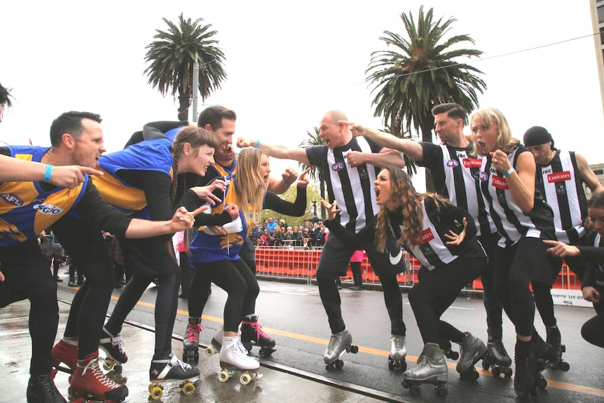 West Coast and Collingwood fans wear roller skates face off against each other in jest at the AFL grand final parade.