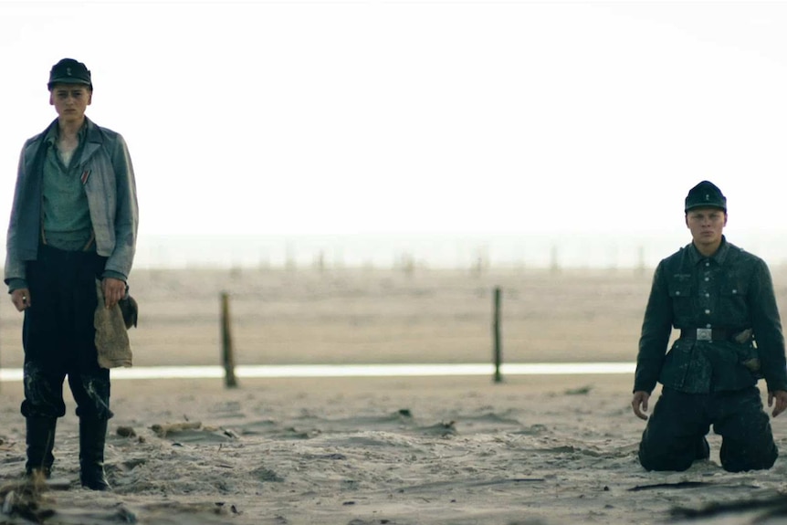 Boys stand on a beach in Land of Mine