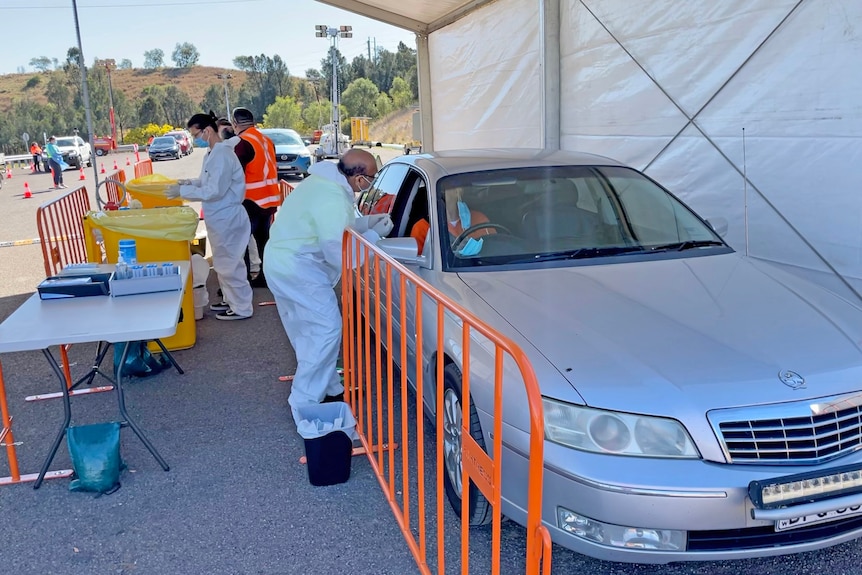 Les agents de santé en EPI administrent des tests aux personnes dans leur voiture