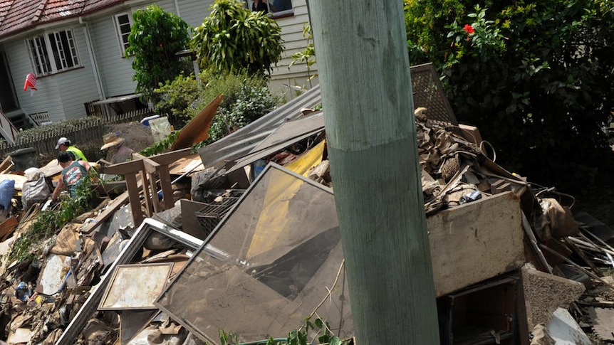 A volunteer throws rubbish into a truck in the flood-hit Brisbane suburb of Graceville on January 16, 2011.