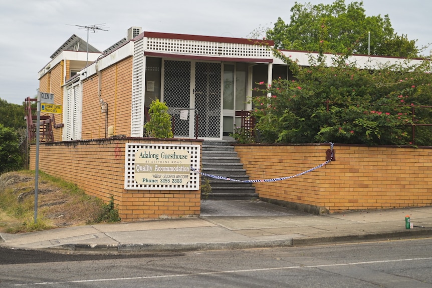 A small guesthouse with police tape across the entrance.