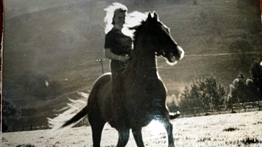 Black and white photo of Sally Malfroy riding her former racehose.