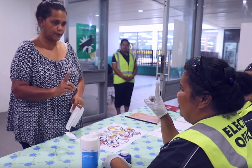 A Nauru Electoral Commission staff member provides information to a voter.