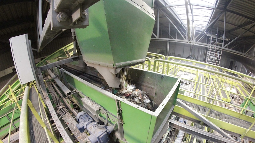 A green industrial machine separating recycled materials