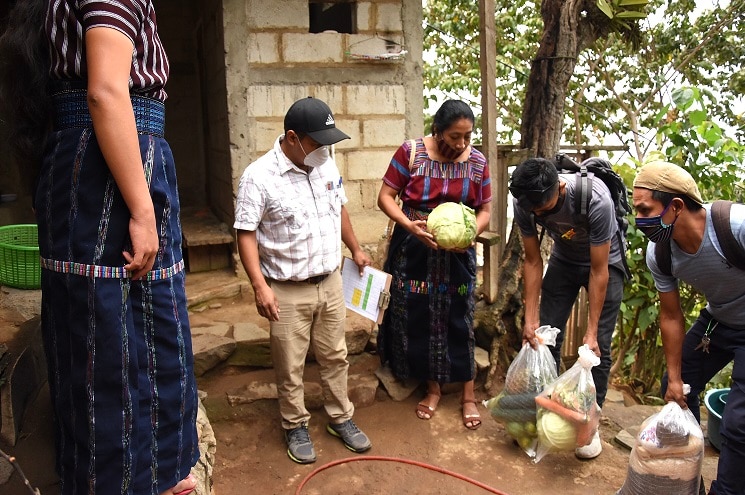 Konojel Program Director Maria Mejia and members of the San Marcos community prepare to distribute aid.