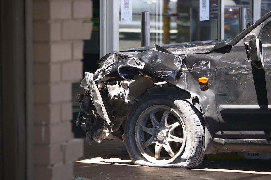 The crumpled front of a black car.