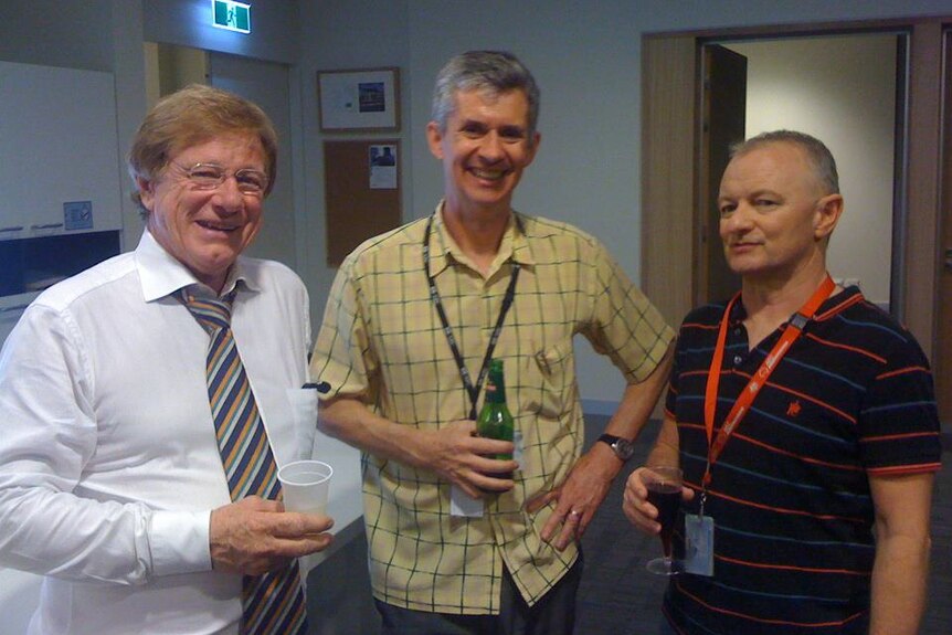 O'Brien, Napper and Green smiling to camera and holding drinks.
