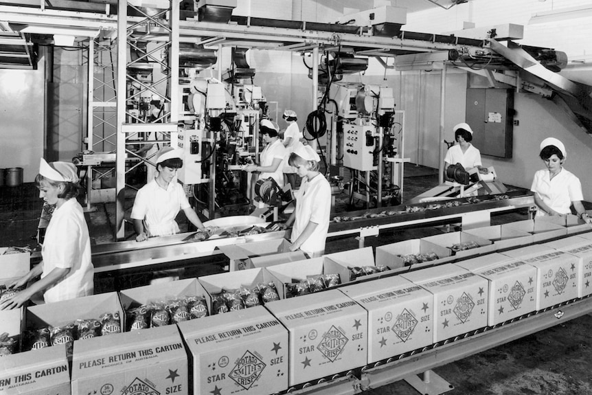 Women packing boxes of Smith's Chips in factory.