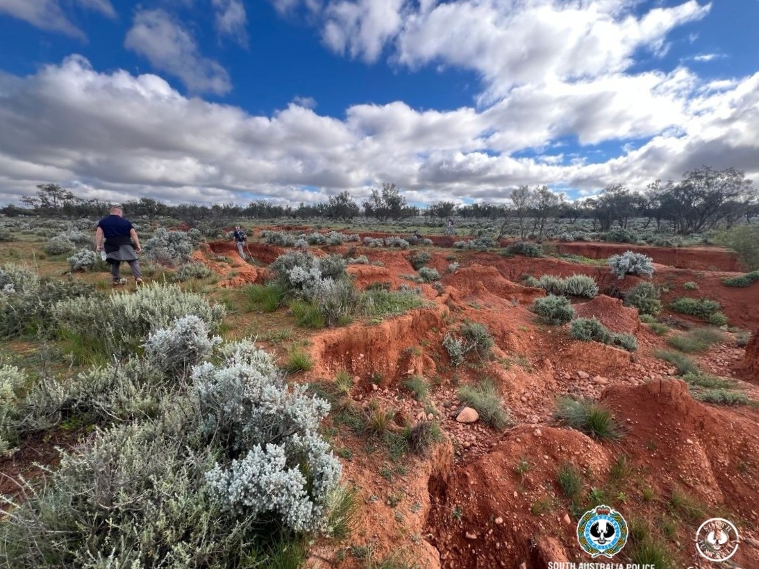 Outback terrain during a police search.