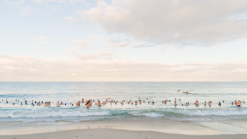 A group of young people swimming in the ocean.