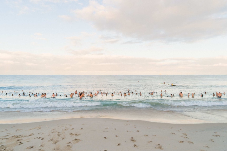 A group of young people swimming in the ocean.