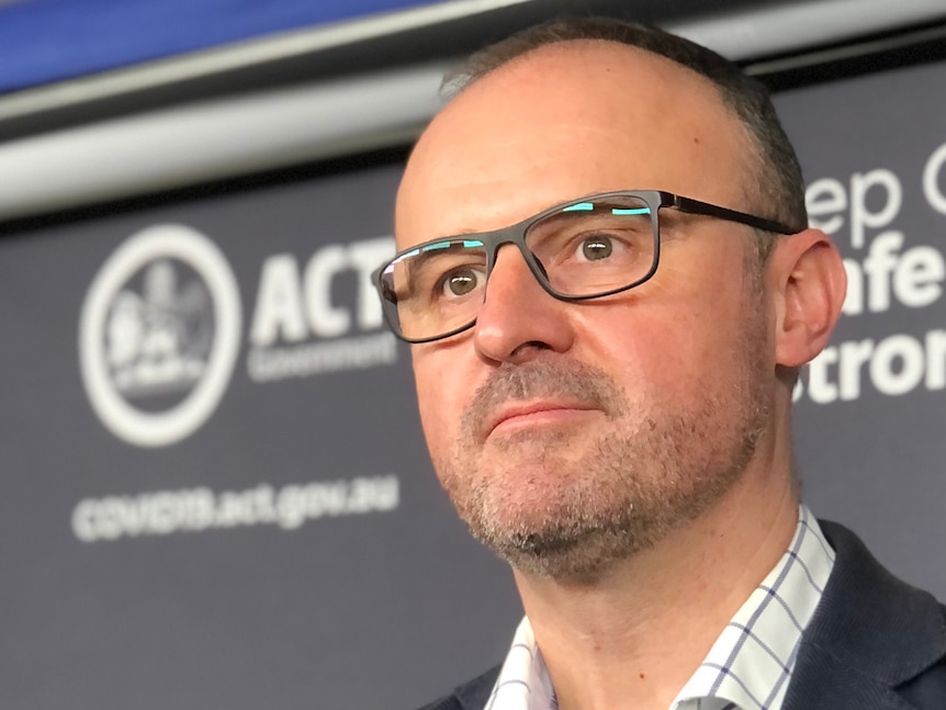 A close up of Andrew Barr listening to a question at a press conference.