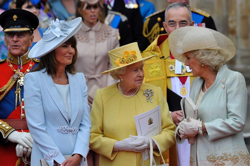 Queen Elizabeth in a cheery yellow, with Carole Middleton, mother of the bride, and Camilla, Duchess of Cornwall.