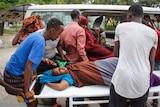 Medical workers and other Somalis help a civilian woman